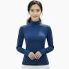 一位穿著藍色長袖小立領保暖內搭衣的女性，搭配白色瑜珈褲。